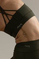 Hey Honey dark green sports bra with criss-cross back straps and matching leggings, featuring a snake tattoo.