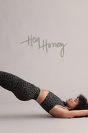 Hey Honey model in olive leopard print leggings and sports bra doing a bridge pose.