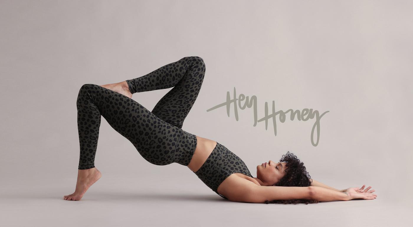 Hey Honey model in leopard print leggings and matching sports bra doing a bridge pose.
